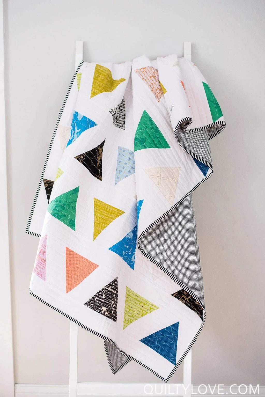 Colorful geomatric quilt drapped Triangle Pop by Quilty Love