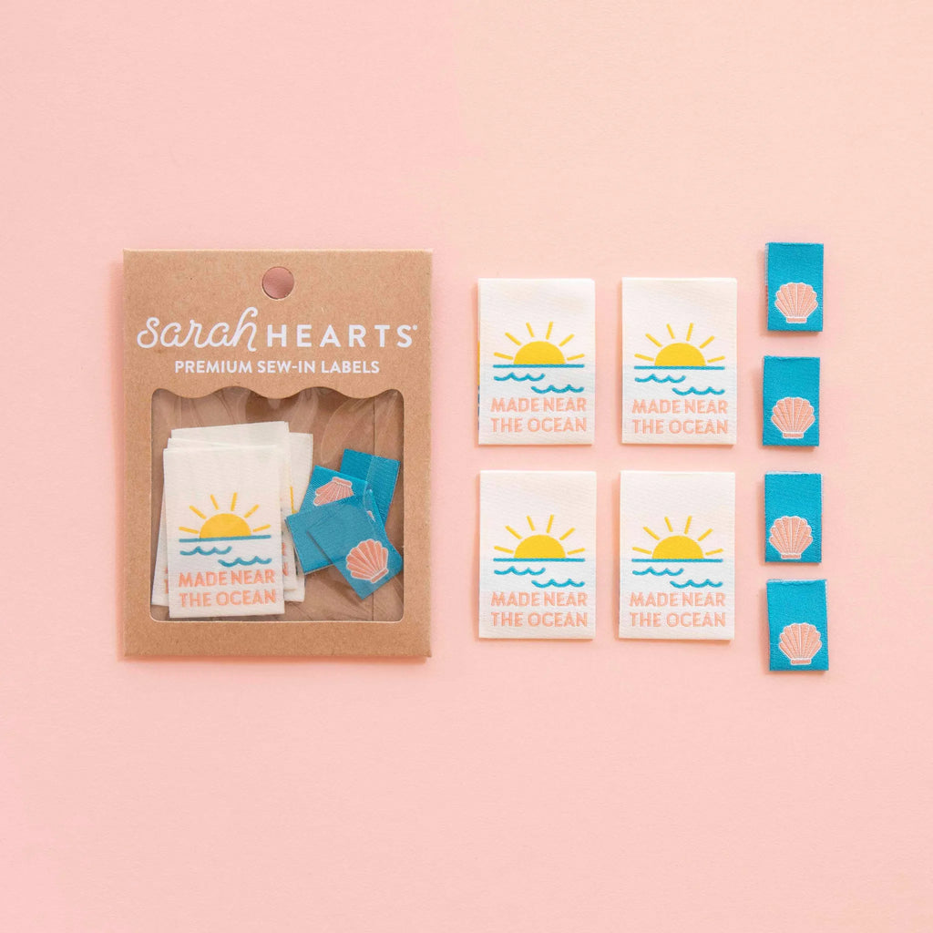 Packaging of Sarah Hearts premium sew-in labels on a pink background