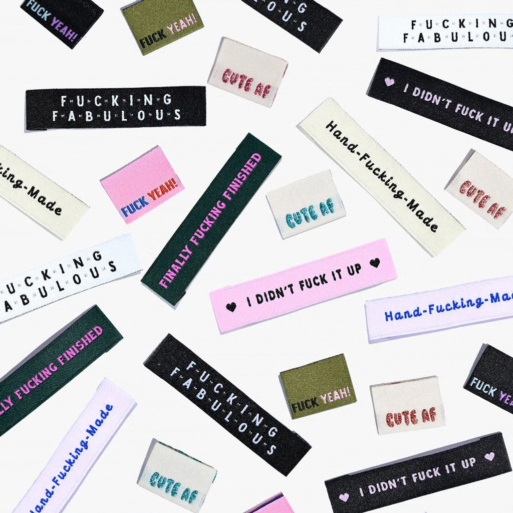 Colorful "Cute AF!" woven labels by KATM in playful fonts.