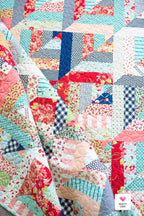 Colorful patchwork quilt with various patterns and colors. Lucky Log Cabin by Quilty Love
