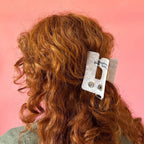 Person with wavy red hair wearing a sewing machine hair clip from Sarah Hearts
