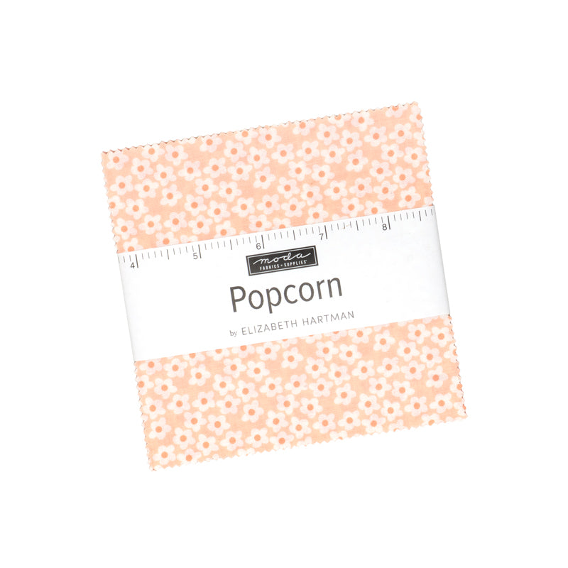 Popcorn by Elizabeth Hartman charm pack for Moda, a stack of 5-inch squares with a paper wrapper over a peach daisy print.