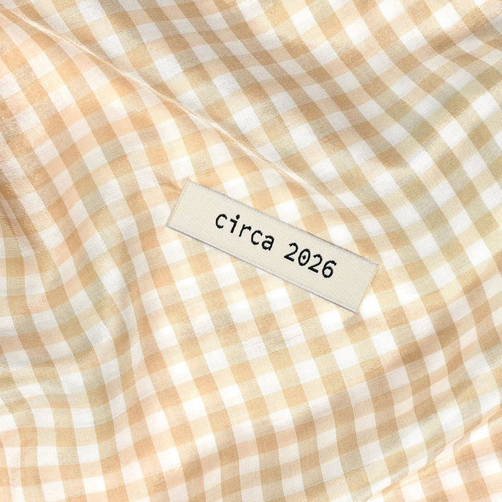 Close-up of a checkered fabric with a 'circa 2026' label. KATM Labels
