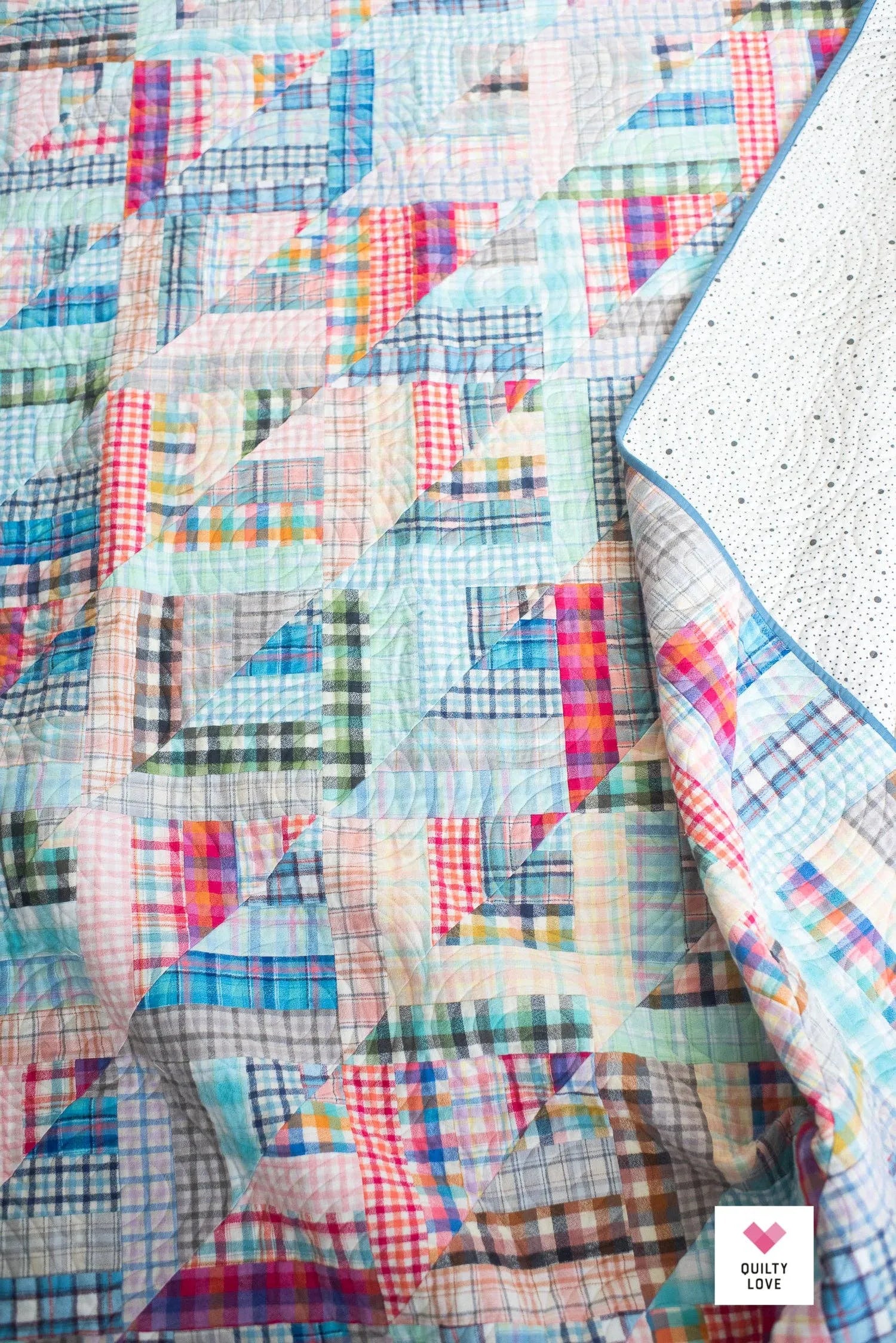Colorful patchwork quilt with geometric patterns on a textured surface Lucky Log Cabin by Quilty Love