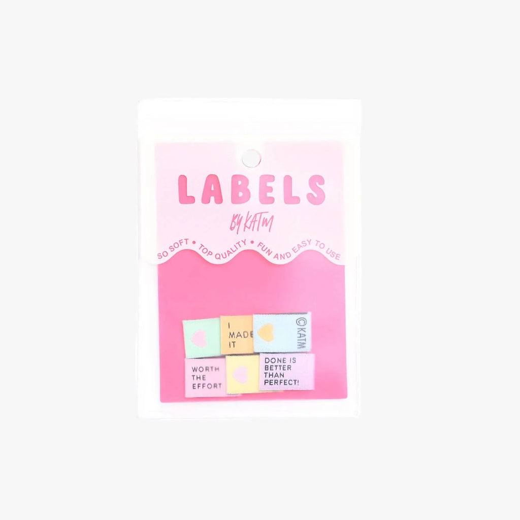 Pack of colorful labels with text on a pink card against a white background KATM Woven Labels