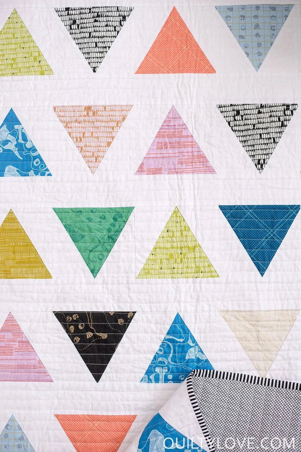 Closeup of scrappy quilt Triangle Pop by Quilty Love
