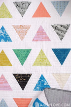 Closeup of scrappy quilt Triangle Pop by Quilty Love